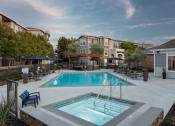 Thumbnail 17 of 36 - Salt Water Pool With Bubbling Spa, Lounge Chairs, Umbrellas, Outdoor Seating Area With Firepit Under A Pergola, And Outdoor Barbeque Area at Montrachet Apartments, California