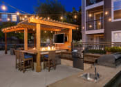 Thumbnail 19 of 36 - Outdoor grill and seating area with TV at Montrachet Apartments, Napa, 94558