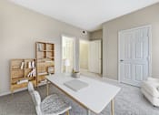 Thumbnail 10 of 19 - A room with a desk, chairs, and a bookshelf.