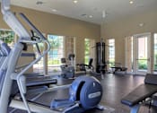 Thumbnail 15 of 19 - Three-Bedroom Apartments in Upland, CA - Park Central Apartments - Fitness Center with Cardio Equipment, Recessed Lighting, Large Windows, and a Glass Door.