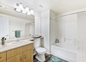 Thumbnail 6 of 19 - A white bathroom with a toilet, sink, and bathtub.
