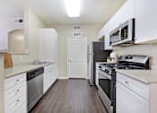 Thumbnail 8 of 19 - A kitchen with white cabinets and stainless steel appliances.