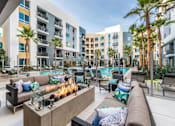 Thumbnail 9 of 30 - A modern outdoor seating area with a fire pit at Rize Irvine, California