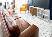 Thumbnail 23 of 43 - Brown leather couch at Urbana Apartments, California, 91910