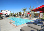 Thumbnail 17 of 87 - West Sacramento, CA Pet-Friendly Apartments - The Strand - Pool with Spa, Sundeck, Red Umbrellas, and Lounge Chairs.