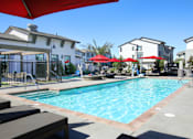 Thumbnail 18 of 87 - A swimming pool surrounded by lounge chairs and umbrellas.