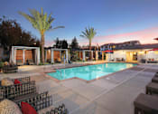 Thumbnail 19 of 87 - A poolside area with lounge chairs and palm trees.
