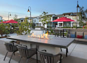 Thumbnail 20 of 87 - A patio with a fire pit and chairs.