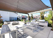 Thumbnail 26 of 87 - A patio with a table and chairs under a shade sail.