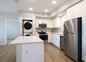 Thumbnail 53 of 87 - A modern kitchen with a refrigerator on the right.