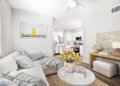 Thumbnail 63 of 87 - Pet-Friendly Apartments in West Sacramento, CA - The Strand - Living Room with Ceiling Fan, Wood-Style Flooring, Area Rug, Sectional Couch, Circular Coffee Table, Armchair, White Walls, and Large Window.