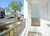 Thumbnail 65 of 87 - A balcony with a view of a parking lot and buildings.