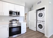 Thumbnail 66 of 87 - A modern kitchen with white cabinets and stainless steel appliances.