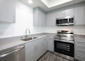 Thumbnail 73 of 87 - A modern kitchen with stainless steel appliances and white cabinets.
