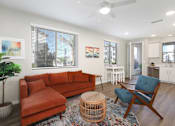 Thumbnail 80 of 87 - A living room with a red couch and a blue chair.