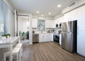 Thumbnail 81 of 87 - A modern kitchen with white cabinets and stainless steel appliances.