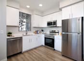 Thumbnail 82 of 87 - A modern kitchen with stainless steel appliances and white cabinets.