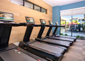 Thumbnail 29 of 85 - A gym with treadmills and screens on the wall.