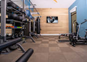 Thumbnail 30 of 85 - A gym with a variety of equipment including weights and a treadmill.