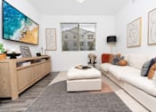 Thumbnail 56 of 85 - A modern living room with a white couch and a wooden entertainment center.