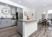 Thumbnail 50 of 85 - A modern kitchen with a large island and a dining table.