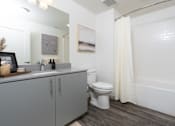 Thumbnail 68 of 85 - A white bathroom with a toilet, sink, and bathtub.