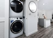 Thumbnail 67 of 85 - A modern laundry room with a washing machine and a dryer.
