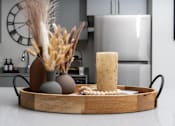 Thumbnail 57 of 85 - A wooden tray with a vase, a candle, and some decorative items on a kitchen counter.