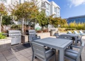 Thumbnail 25 of 50 - an outdoor patio with tables and chairs and barbecue grills at Strata at Mission Bay, San Francisco