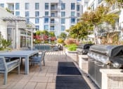 Thumbnail 26 of 50 - a patio with a table and chairs and a barbecue grill at Strata at Mission Bay, San Francisco, 94158
