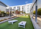 Thumbnail 29 of 50 - Outdoor Recreation Area with Artificial Turf, Corn Hole Boards, Landscaped Plants, Gravel, Seating Area  at Strata at Mission Bay, San Francisco