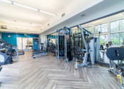 Thumbnail 30 of 50 - a gym with cardio machines and weights in a building with large windows at Strata at Mission Bay, California, 94158