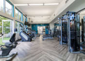 Thumbnail 31 of 50 - a gym with cardio machines and weights in a building with large windows at Strata at Mission Bay, San Francisco, 94158