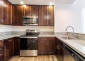 Thumbnail 39 of 50 - a kitchen with wooden cabinets and granite counter tops and stainless steel appliances at Strata at Mission Bay, California, 94158