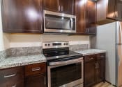 Thumbnail 38 of 50 - a kitchen with wood cabinets and stainless steel appliances and granite counter tops at Strata at Mission Bay, San Francisco