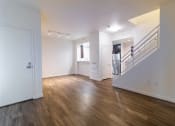 Thumbnail 42 of 50 - an empty living room with white walls and wood floors and a staircase at Strata at Mission Bay, California