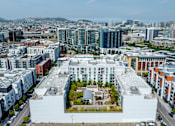 Thumbnail 47 of 50 - A large white building with a courtyard in the middle of a city.