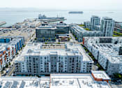 Thumbnail 49 of 50 - A view of a city with a large building in the center and a ship in the background.