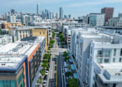 Thumbnail 50 of 50 - A cityscape with buildings and cars on the street.