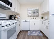 Thumbnail 12 of 39 - a kitchen with white cabinets and appliances and a window at Sunstone Place, Riverside, CA