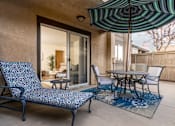Thumbnail 15 of 39 - a patio with chairs and tables and an umbrella at Sunstone Place, Riverside, CA