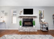 Thumbnail 9 of 142 - A living room with a fireplace and a flat screen TV mounted above it.