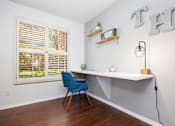 Thumbnail 10 of 142 - A room with a desk, chair, and shelves with plants.