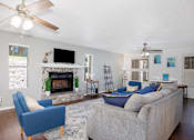 Thumbnail 4 of 142 - A living room with a fireplace, a couch, and a television.
