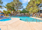 Thumbnail 2 of 142 - A large swimming pool surrounded by trees and chairs.