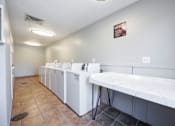 Thumbnail 22 of 142 - A laundromat with a row of washers and dryers.