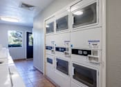 Thumbnail 23 of 142 - A row of white ovens are lined up in a kitchen.