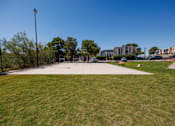 Thumbnail 40 of 142 - A park with a fence and a building in the background.