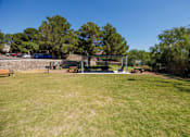 Thumbnail 41 of 142 - A park with a playground and picnic tables.