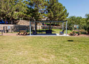Thumbnail 42 of 142 - A park with a swing set and picnic tables.